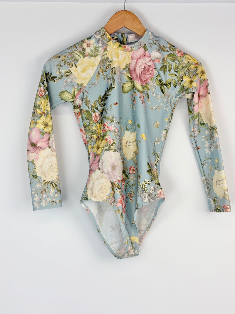 Floral patterned swimsuit on a hanger against a white background