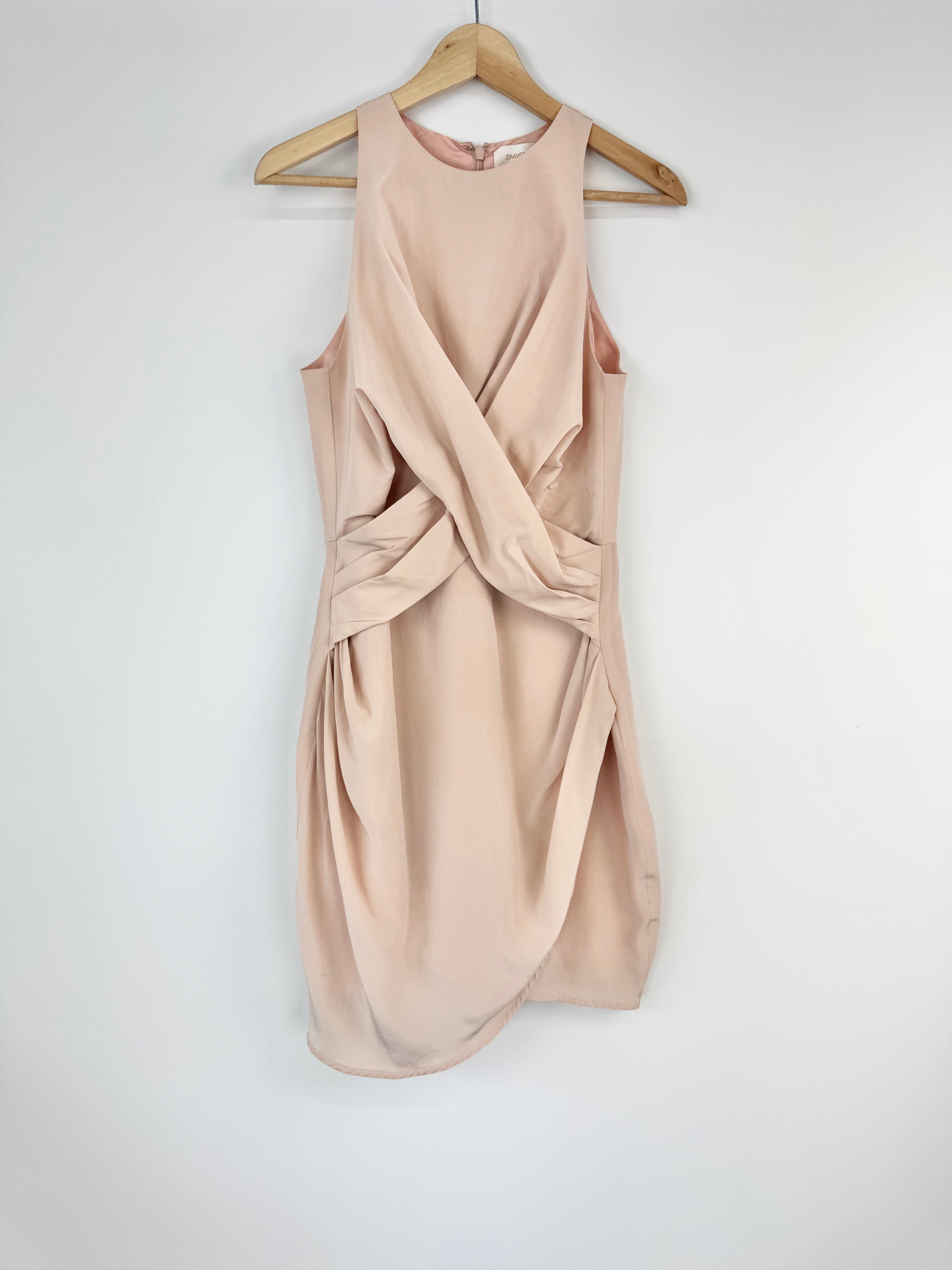 Peach sleeveless dress on a hanger against a white background