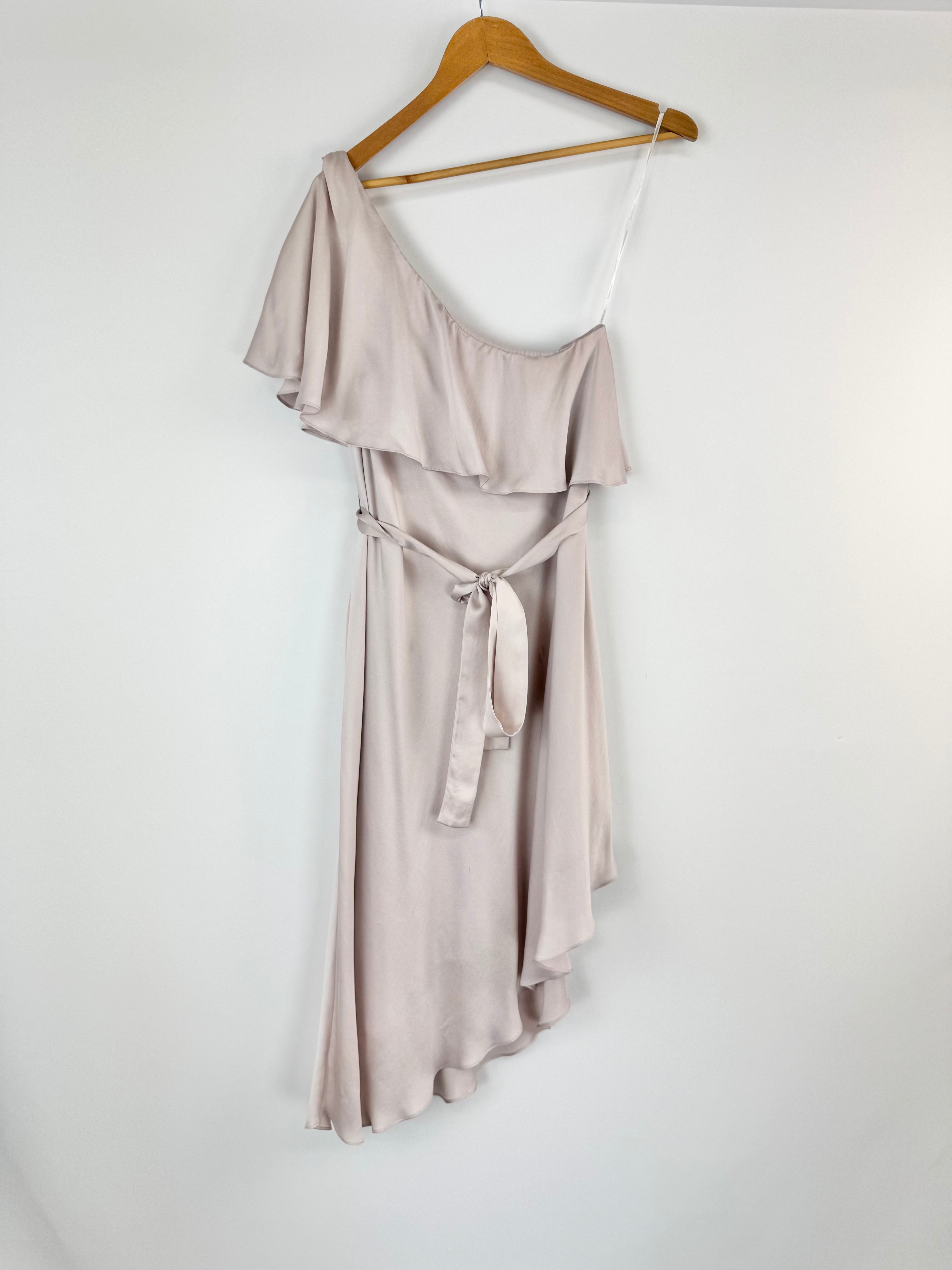 Light purple one-shoulder dress on a wooden hanger against a white background
